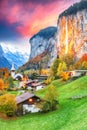 Captivating autumn view of Lauterbrunnen valley with gorgeous Staubbach waterfall and Swiss Alps at sunset time