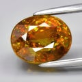 Captivating Close-Up of a Vibrant Orange Garnet Gemstone Held by Precision Tweezers Royalty Free Stock Photo