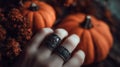 Close-Up of a Pale Hand Adorned with Dark Rings Holding a Tiny Object Royalty Free Stock Photo