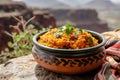 Aromatic Malian Jollof Rice Served in a Traditional Clay Pot Against a Canyon Backdrop Royalty Free Stock Photo