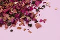 Dry tea leaves and rose petals on a pink background. Royalty Free Stock Photo