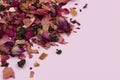 Dry tea leaves with rose petals on a pink background. Royalty Free Stock Photo