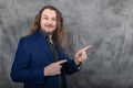 Suave man with long hair in sleek blue suit striking different confident standing poses