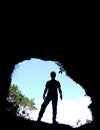 Silhouette of a man in backlit entrance, inside view of a cave Royalty Free Stock Photo
