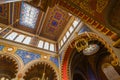 A captivating interior view of a synagogue showcasing its ornate ceiling with geometric patterns, arched windows, Royalty Free Stock Photo