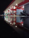 Night\'s Glow: Reflections at a Rain-Kissed Gas Station