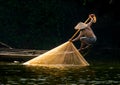 A captivating shot of Vietnamese fishermen throwing a large fishnet in the Song Nhu Y River