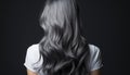 Captivating shot of a woman\'s silver-grey hair with a shimmering finish, gracefully falling against a deep black background