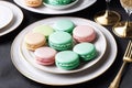 A platter on the table is adorned with numerous macarons, creating a colorful and enticing display.