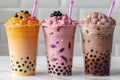 Captivating visual featuring three boba teas in different colors, one with orange milk and black pearls on top, the second ha Royalty Free Stock Photo