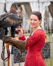 Captive wedge tailed eagle with female trainer / handler in red dress getting ready for flight exhibition at a show