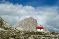 A capture of a small chapel, with red rooftop and small bell tower in Italian Dolomites. There are high Alpine peaks around. Royalty Free Stock Photo