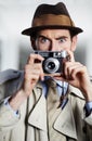 Captured in the act. Private detective capturing a photo using a retro camera. Royalty Free Stock Photo