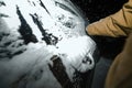 Nighttime Snow Removal from Frozen Car Windows After Tempest