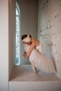 Captured in soft light, ballerina in thoughtful pose reflects quiet strength, introspection of art