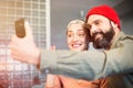 Capturing happy moments. Beautiful young loving couple bonding to each other and making selfie while sitting on the sofa Royalty Free Stock Photo