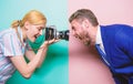 Capturing his face expression. Pretty woman using professional camera. Photographer shooting male model in studio Royalty Free Stock Photo