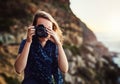 Capturing memories through a lens. Portrait of a young woman taking photos with her camera outdoors. Royalty Free Stock Photo