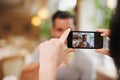 Capturing the moment. A woman taking a picture of her partner while dining out at a fancy restaurant. Royalty Free Stock Photo