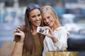 Capturing our girls day out. Two young women holding shopping bags and taking a self-portrait on a cellphone. Royalty Free Stock Photo