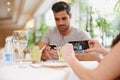 Capturing their times together. A woman taking a picture while dining out with her partner at a restaurant. Royalty Free Stock Photo