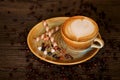 Capuccino with beautiful decorations, along with coffee beans and biscuits Royalty Free Stock Photo