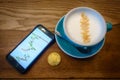 Capuccino and bitcoin gold coin on the table in cafe Royalty Free Stock Photo