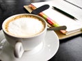 Capuchino coffee with notebook Royalty Free Stock Photo