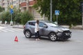 Car accident. The girl costs at the broken car at the intersection of roads. Tyumen, Russia.