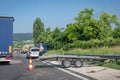 Car accident on highway. Overturned car after collision, ambulance, police car, policeman and deployed platform trailer