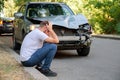 Car accident. Man holding his head after car accident. Man regrets damage caused during car wreck. Man driver is