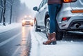 Car accident in winter, Woman waiting for help on the road after an accident on a snowy slippery road, following traffic rules, Royalty Free Stock Photo