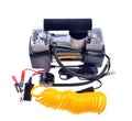 Car air compressor with yellow twisted hose for supplying compressed air on an isolated white