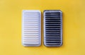 Car air filter change concept. Clean new and old dirty automobile air filters on a yellow background