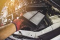 Car air filter in a hand of mechanic man is installing into air filter socket of car engine. Royalty Free Stock Photo