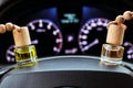 Car air perfume freshener bottles inside the car on the steering wheele. Aromatic liquid in the small bottles. Blurred dashboard
