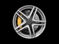 Car alloy wheel and tyre isolated on black background. New alloy wheel with tire and yellow carbon ceramic brakes. Alloy rim