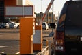 Car approaching to automatic barrier gates for supermarket parking lot. Security system for car park entry to shopping