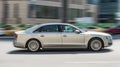 car Audi A8 2014 model fast moving on road in the city with blurred background