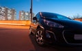 Car in the back of a hatchback in the evening on the background of the evening city. car in the scenery of the city. long exposure