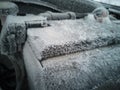 Car battery close-up. The engine compartment is covered with snow and ice after a long parking Royalty Free Stock Photo