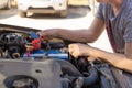 Car battery repair and inspection. The man measures the voltage and capacity of the battery with a tester. Car service Royalty Free Stock Photo