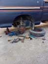 the car is being repaired tires, wheels removed with wrench and jack tools.