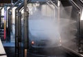 Car being spray washed in a automated car wash, bright purple, red and yellow indicator lights on