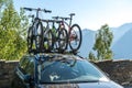 Car with 4 bicycles on the roof prepared for the family vacation outdoors. Two children and two adults bicycles. Concept of family