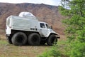 A car with big wheals for off-road. All-terrain cross-country vehicle Trackol on the background of mountain in tundra.