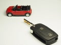 Car black key remote controller and small toy car on white background Royalty Free Stock Photo