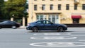 car BMW 430i xDrive G22 coupe on the road in motion. Fast speed drive on city road. Side view of moving BMW 4 Series on the street Royalty Free Stock Photo