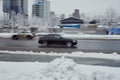 car BMW 3 Series F30 in the winter slippery city street. Side view of black sedan vehicle in motion against blurred urban Royalty Free Stock Photo
