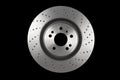 Car brake disc isolated on black background. Auto spare parts. Perforated brake disc rotor isolated on black. Braking ventilated